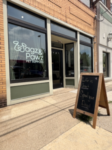 Exterior of Wagz n Pawz Pet Supplies in Newport, Kentucky, featuring a sidewalk chalkboard sign that reads “Life is short… Spoil your dog!” in front of the shop’s brick storefront.