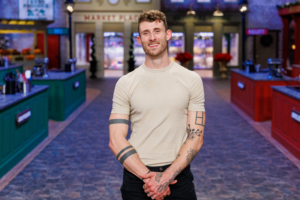Chase Maus, a Kentucky pastry chef and Season 12 contestant on Food Network’s Holiday Baking Championship, smiles on the show’s holiday themed kitchen set.
