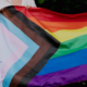People hold a Progress Pride flag during an LGBTQ+ gathering as Kentucky lawmakers consider House Bill 553 affecting gender-affirming care.